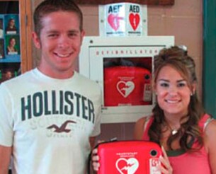 Lindsay holds an AED like the one that saved her life.